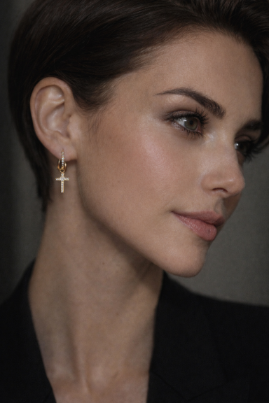 Femme avec un piercing en croix, regard tourné sur le côté, maquillage léger.